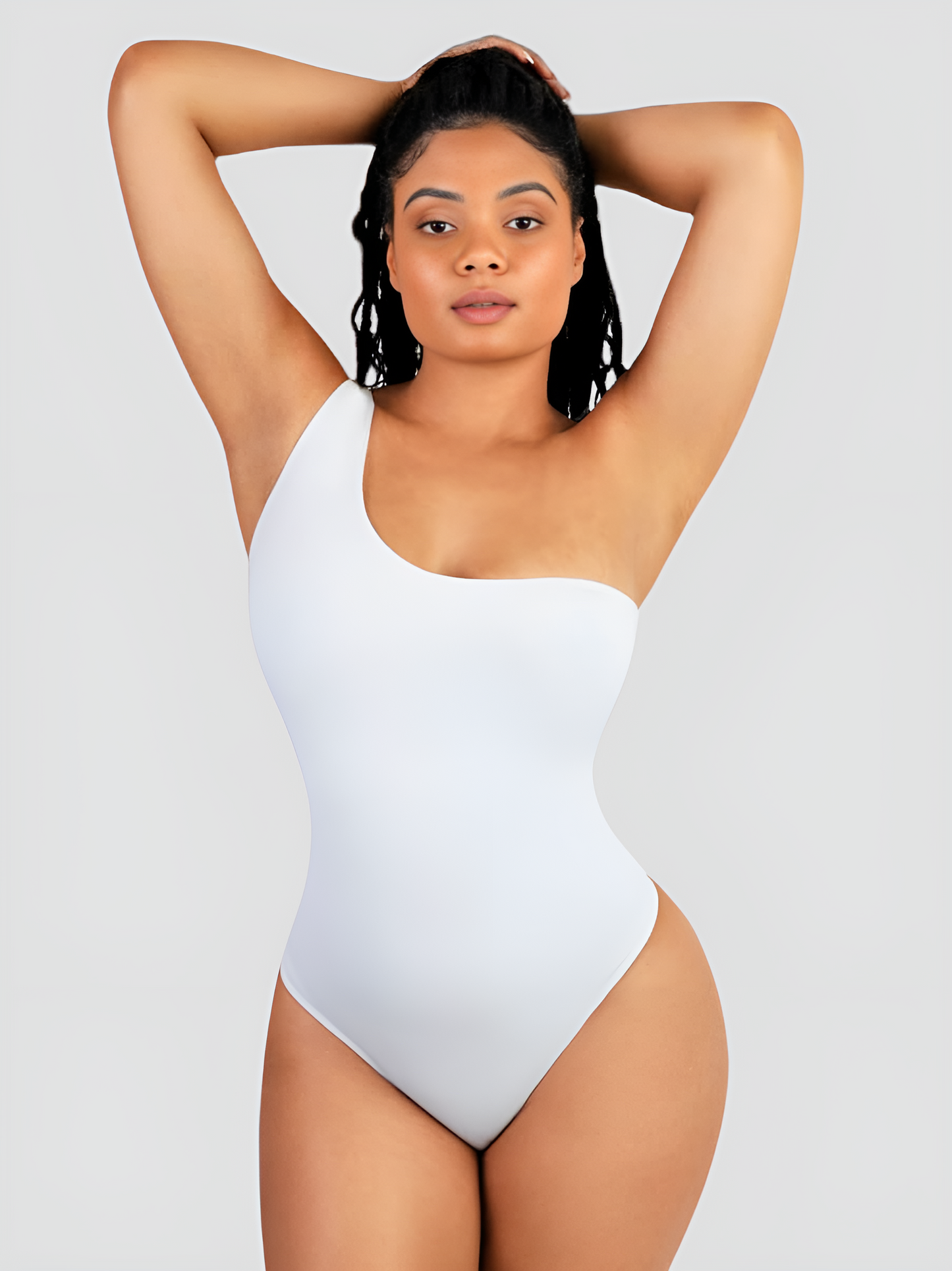 Woman posing wearing a white off-the-shoulder shaping bodysuit with built-in shapewear for tummy-control and hourglass curves.