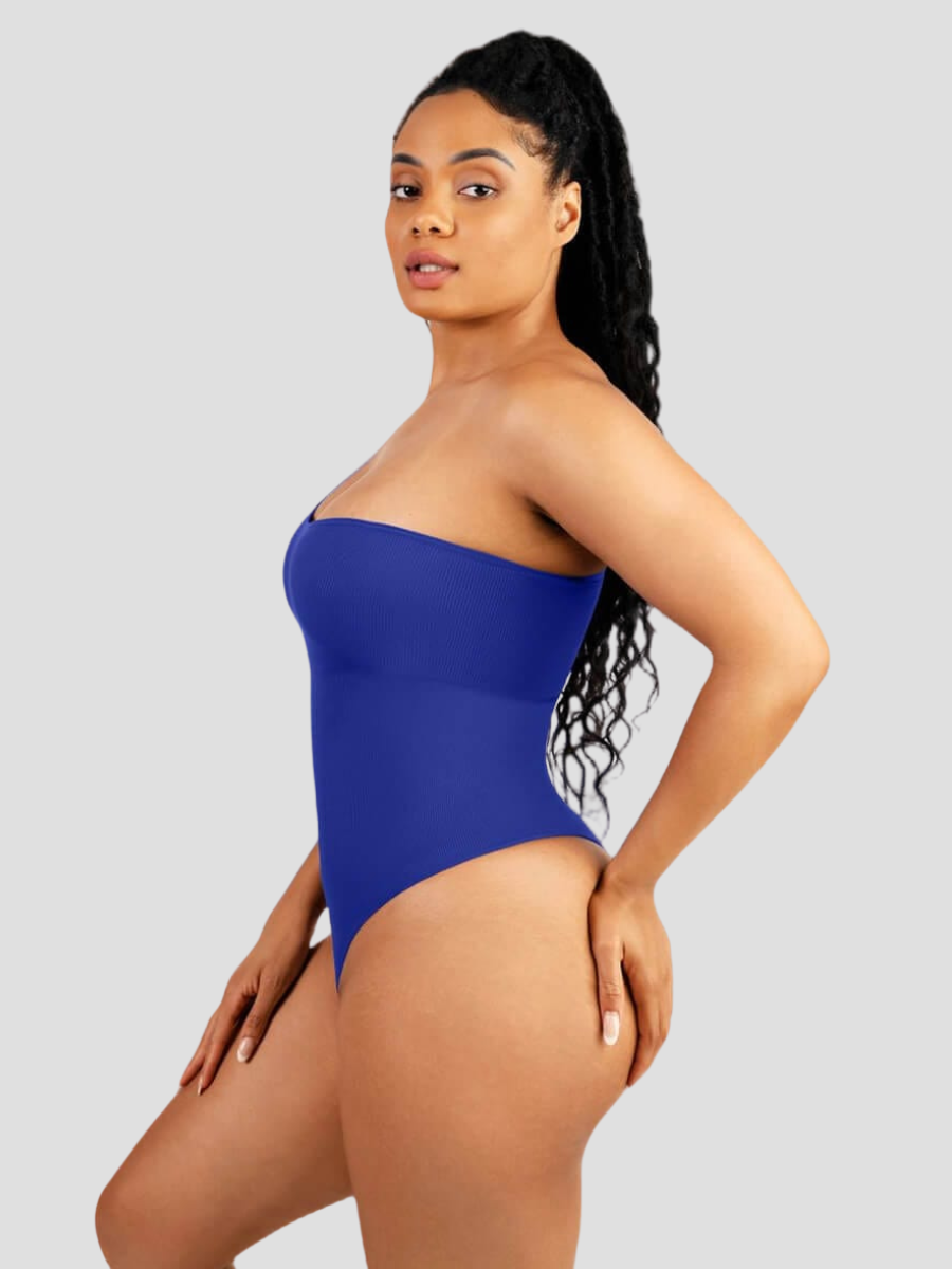 A woman posing wearing a blue off-the-shoulder seamless shaping bodysuit with built-in tummy-control shapewear to show off her curves.