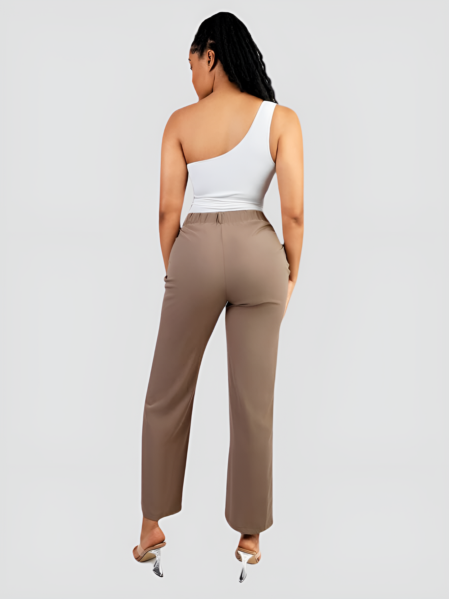 A woman wearing a white off-the-shoulder shaping bodysuit with built-in tummy-control shapewear paired with tan pants.