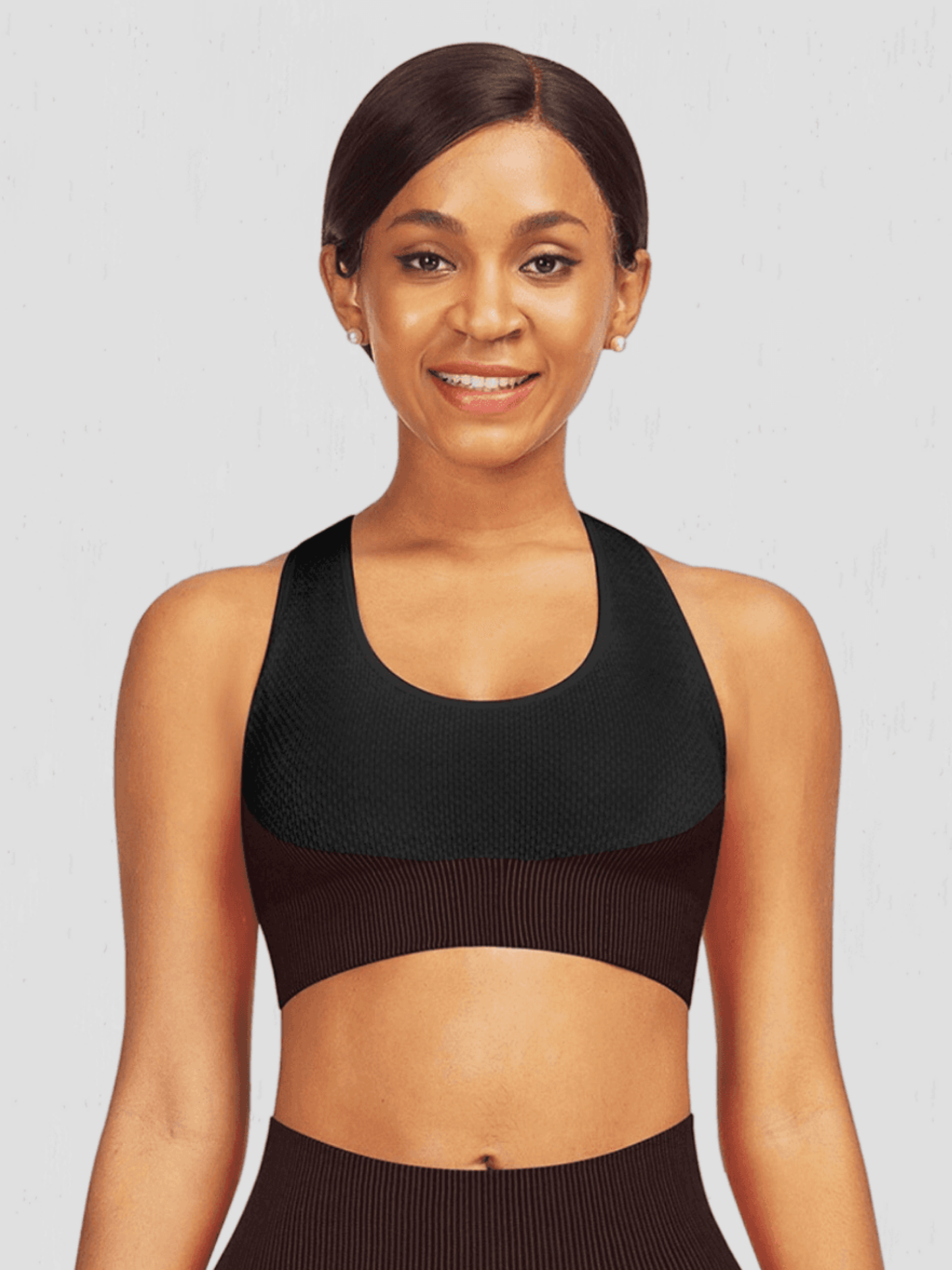 Woman wearing a padded black and fuchsia textured sports bra by BodyFlexx.