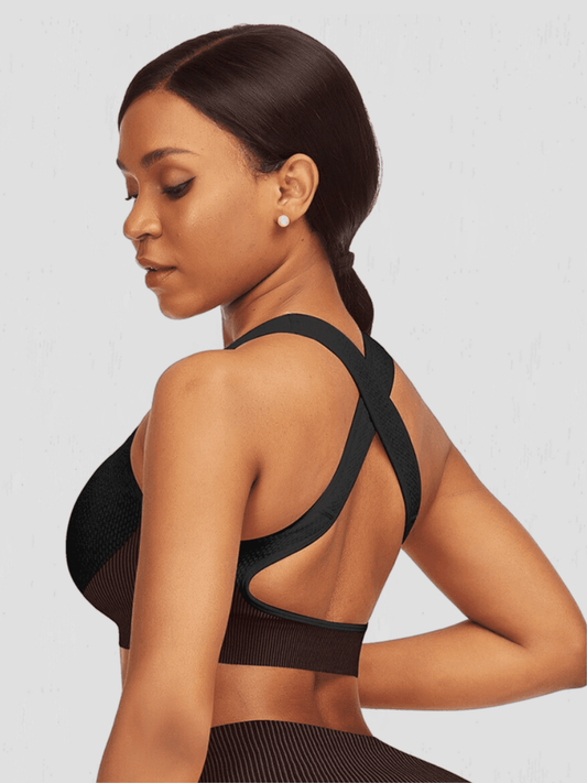 Woman wearing a padded black and fuchsia textured sports bra before a workout.