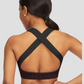 Woman wearing a black and fuchsia sports bra with crisscross straps by BodyFlexx.