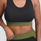 Woman wearing a padded black and green sports bra by BodyFlexx.