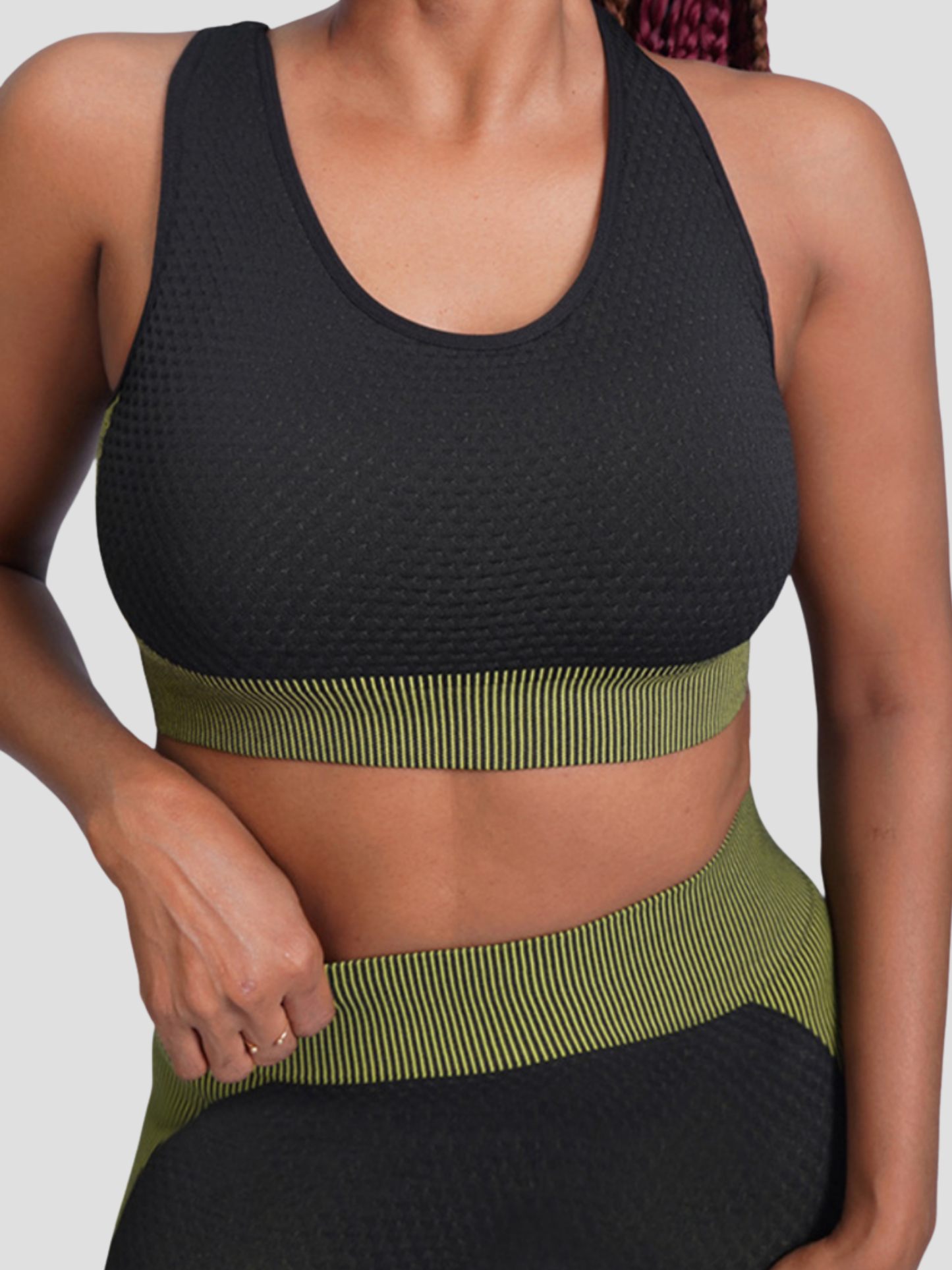 Woman wearing a padded black and green sports bra by BodyFlexx.