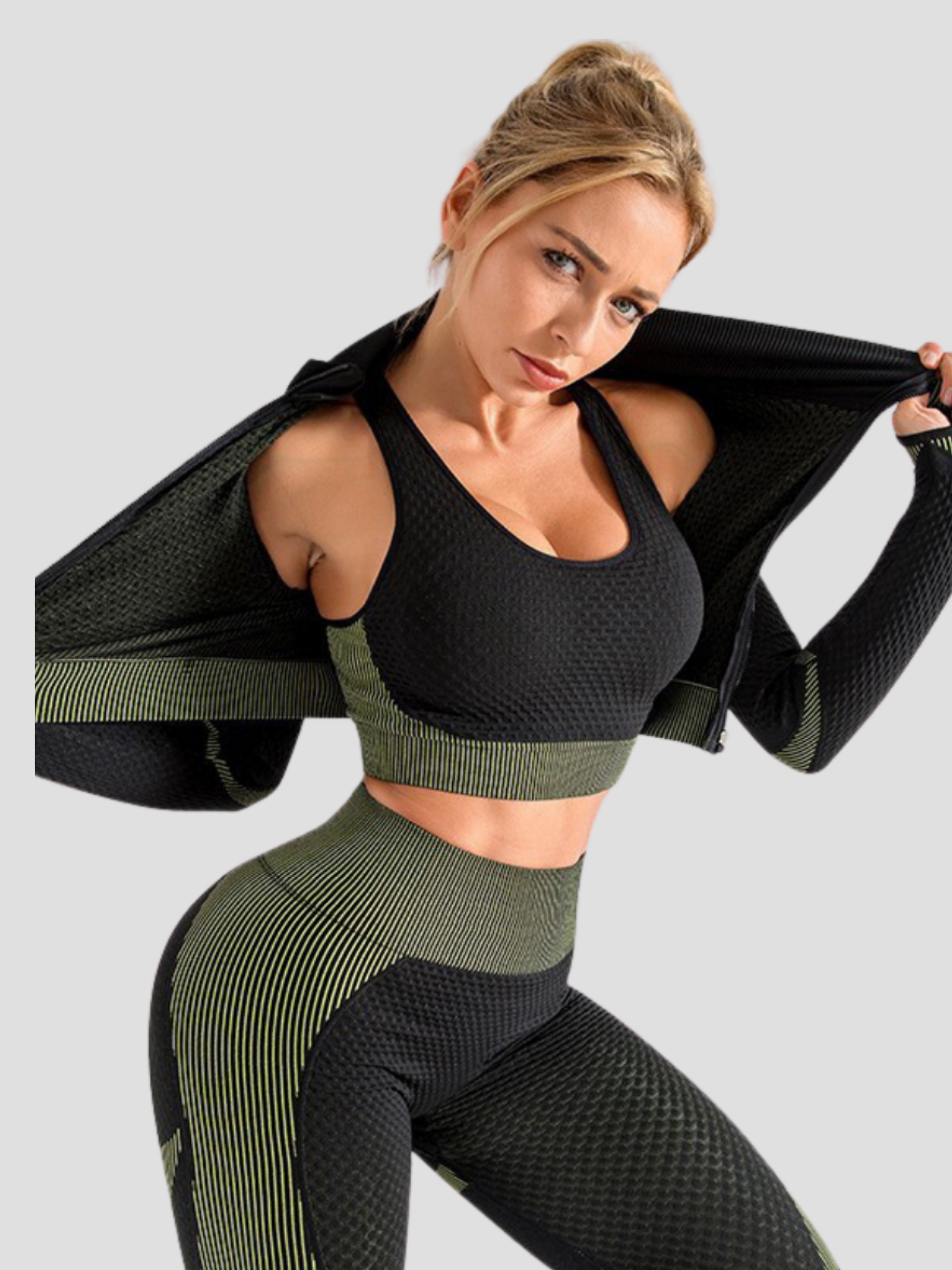 Woman wearing a black and green sports bra with matching leggings and jacket.