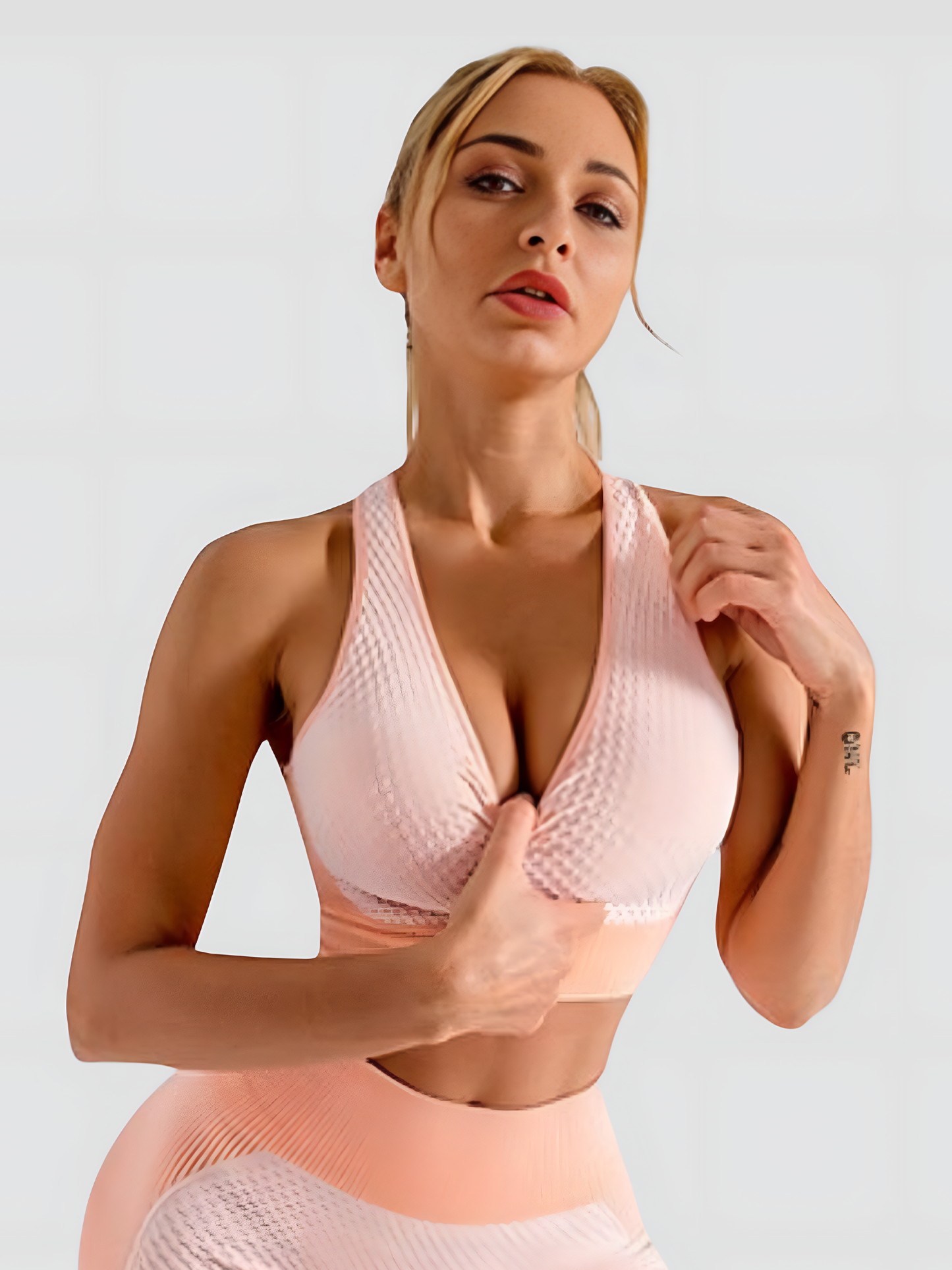 Woman wearing a pink textured sports bra and matching leggings by BodyFlexx.