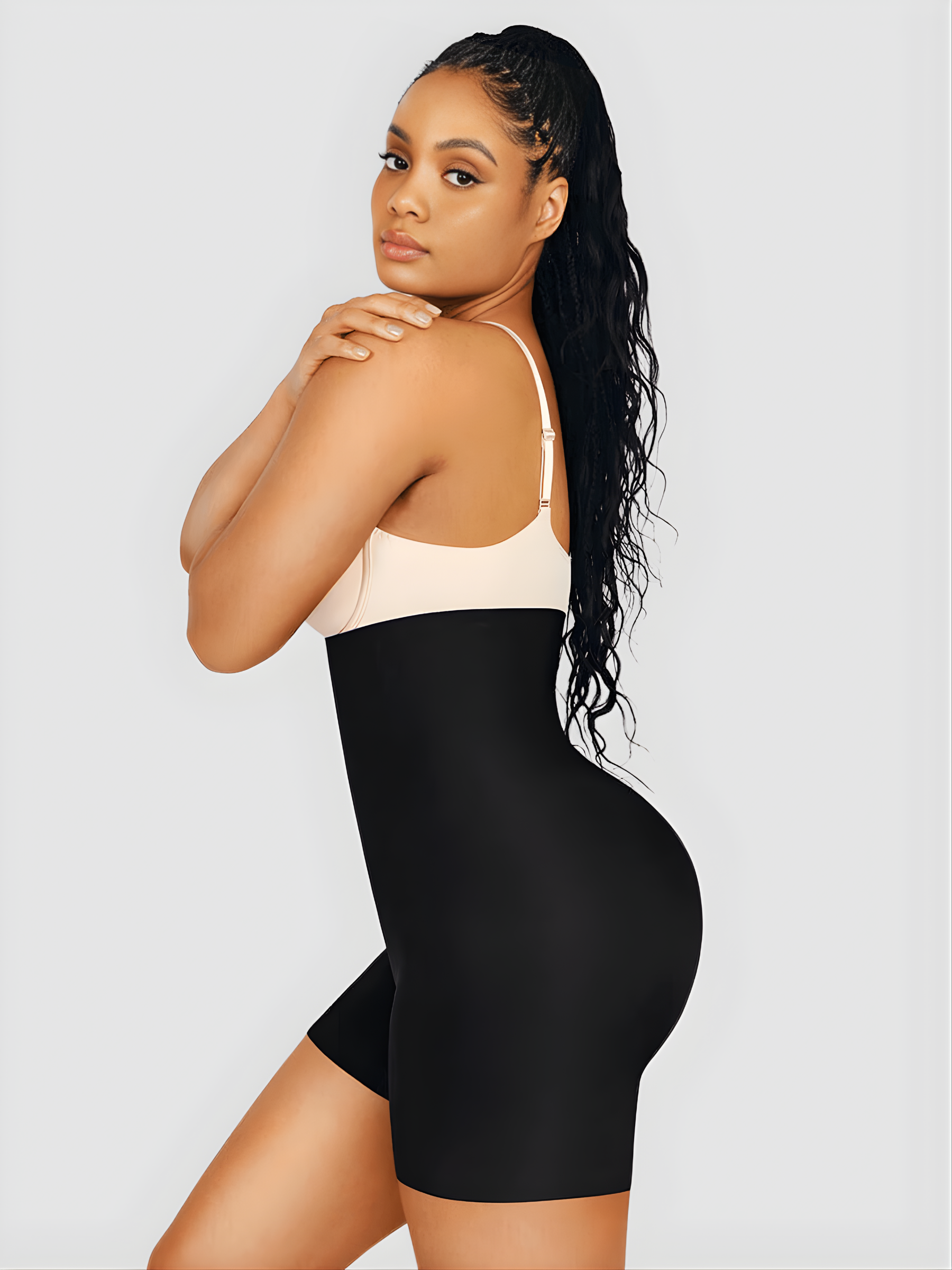 Woman wearing high waisted black shapewear bottoms with removable hip pads and tummy-control by BodyFlexx.