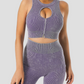Woman wearing a ribbed purple halter sports bra with a peekaboo hole in the front and matching leggings.