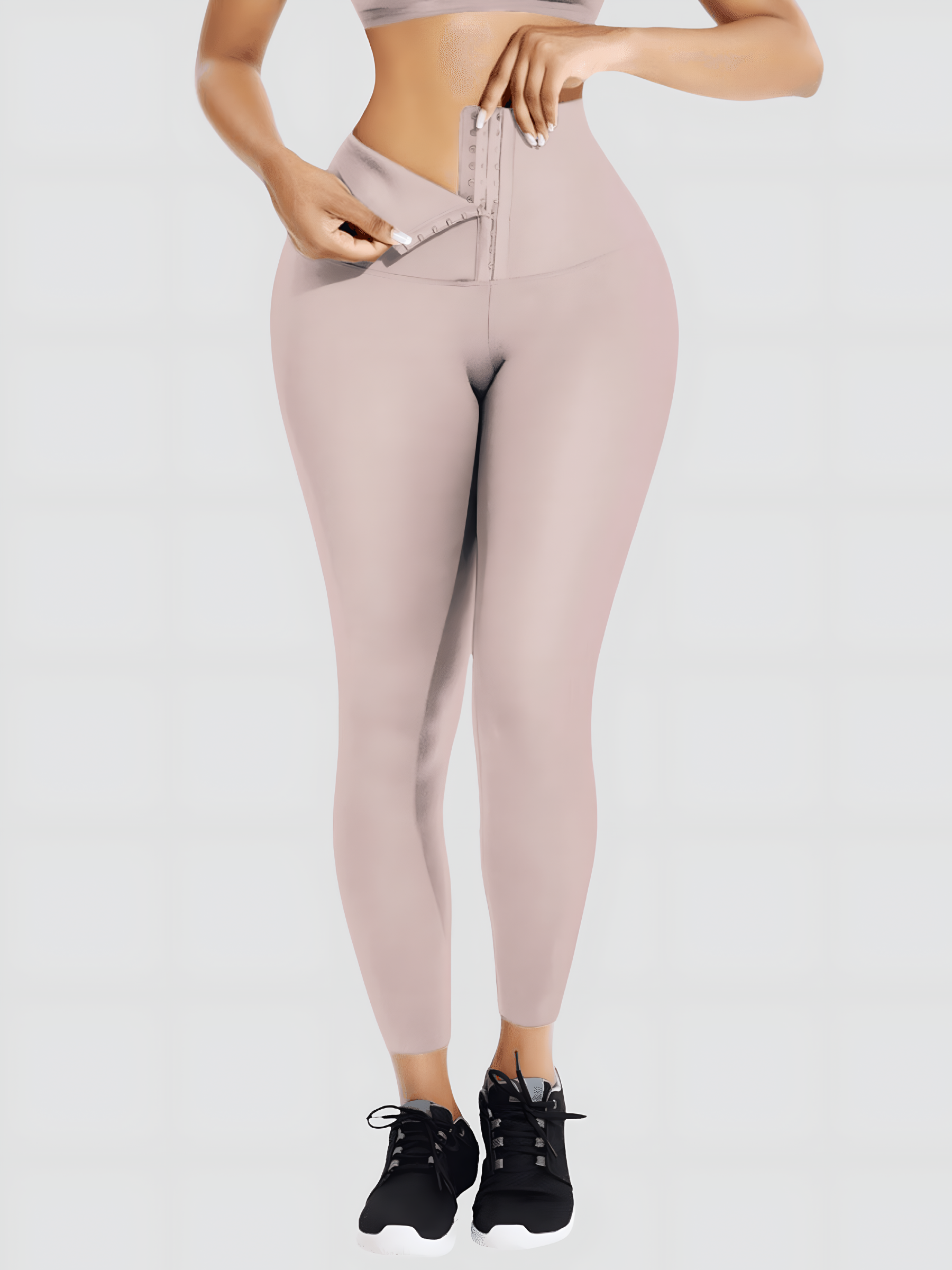 Woman wearing high waisted light pink waist training leggings with a 3 row hook-and-eye corset closure by BodyFlexx Shapewear.