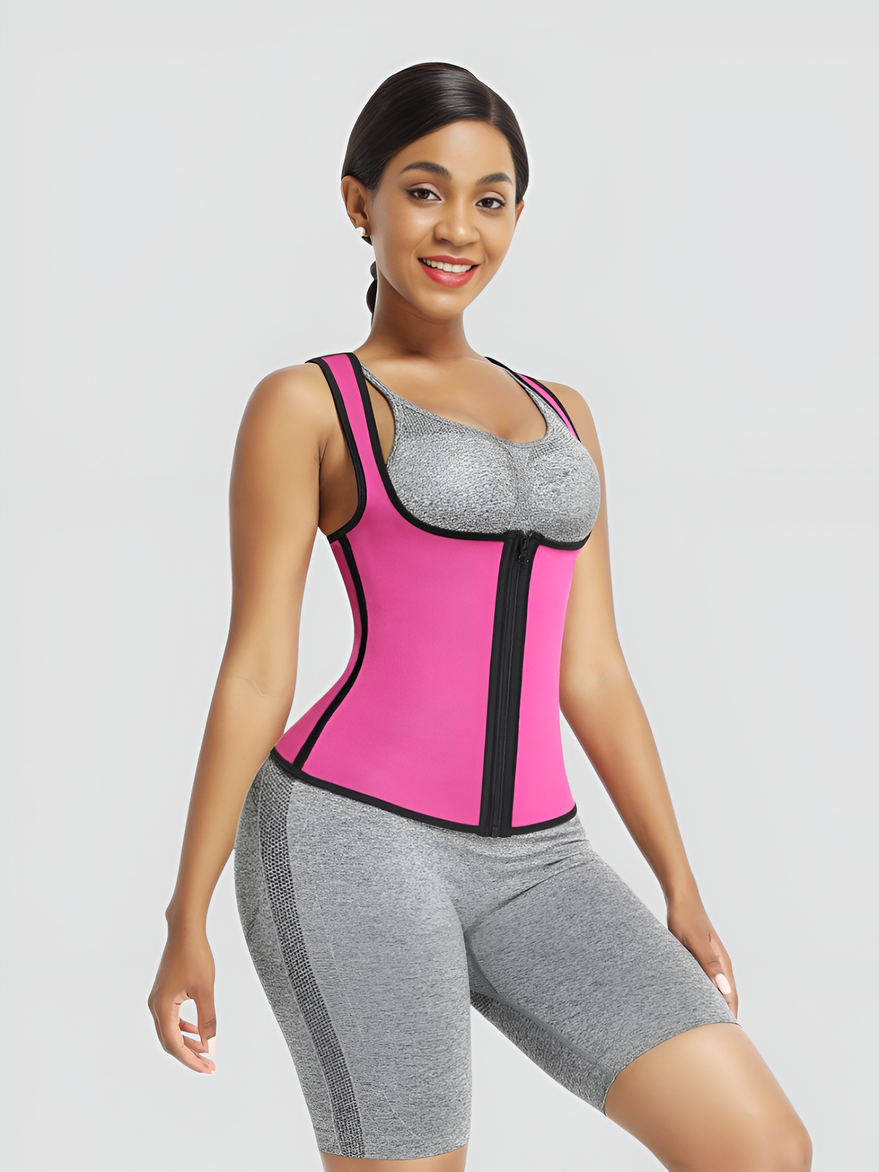 Woman wearing a pink and black neoprene-lined waist training vest before a workout.