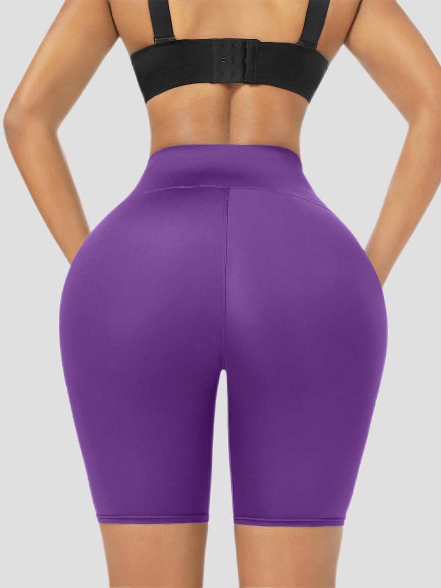 Woman wearing high-waisted purple sauna activewear shorts showing a close up of her bum. 
