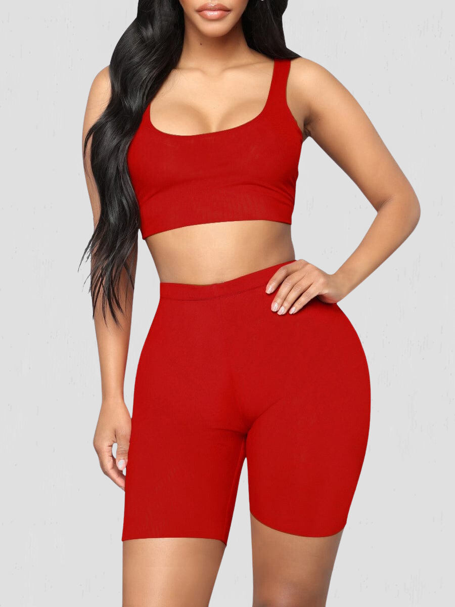Woman wearing a red matching shorts and sports bra activewear set by BodyFlexx.