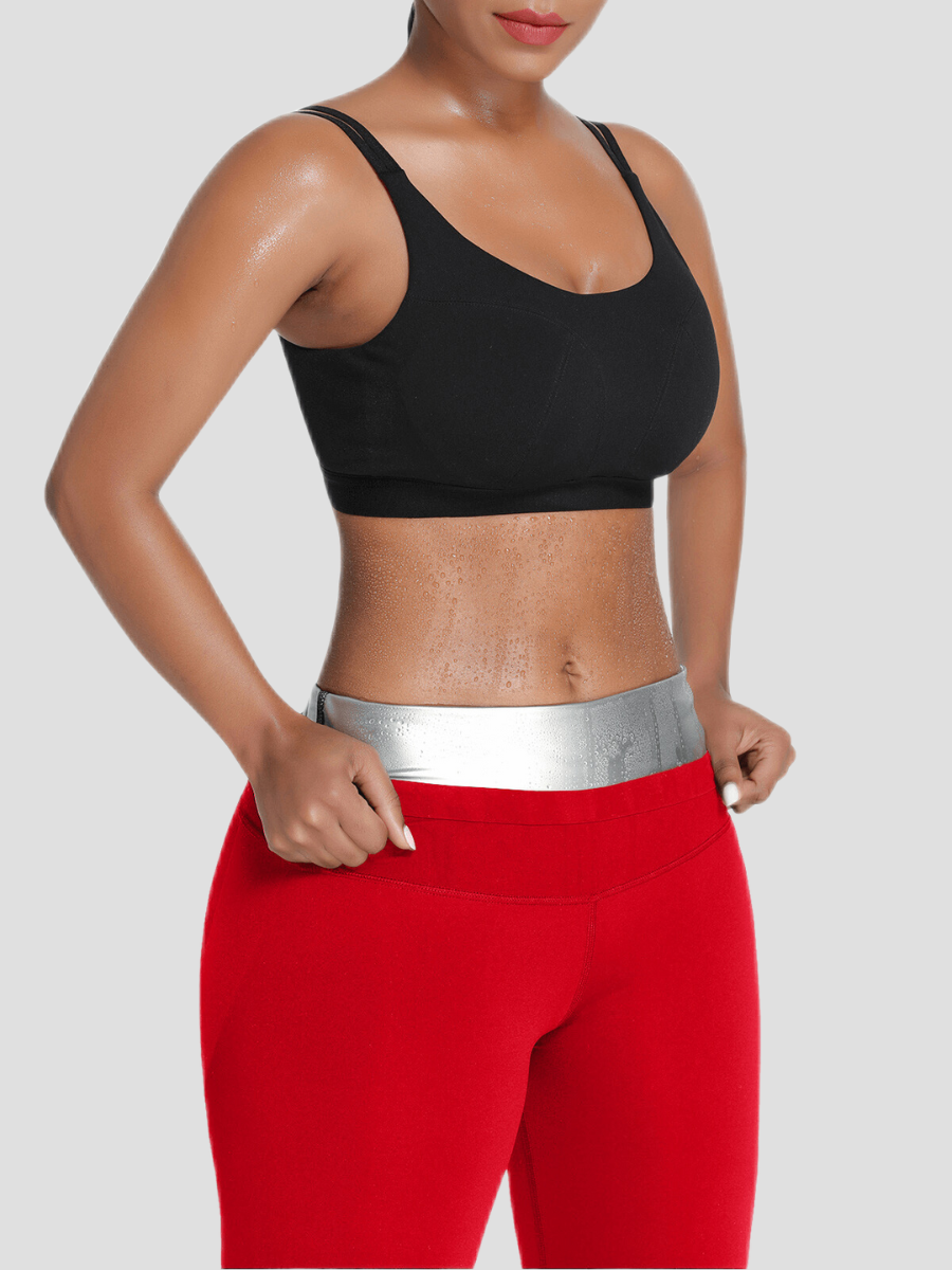 Woman wearing red sauna activewear shorts and a silver-neoprene lining for weight loss showing how much her tummy is sweating after a workout.