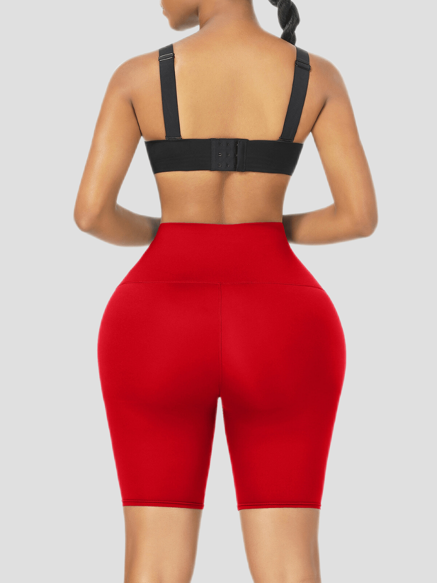 Woman wearing red sauna activewear shorts and a black activewear top facing backwards.