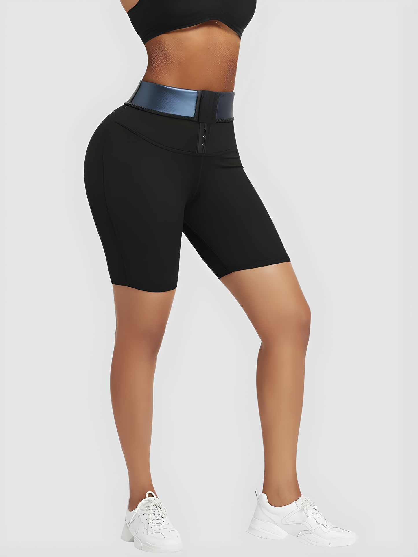 Woman wearing black mid-thigh sauna shorts with a corset closure showing the blue neoprene lining.