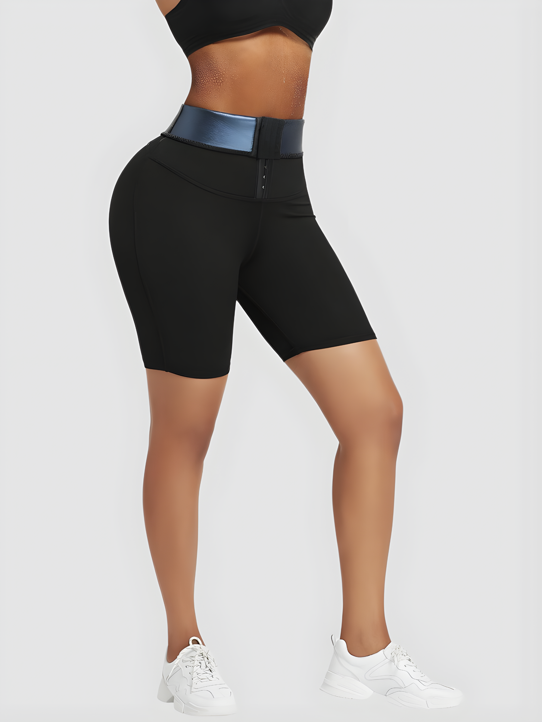 Woman wearing black mid-thigh sauna shorts with a corset closure showing the blue neoprene lining.