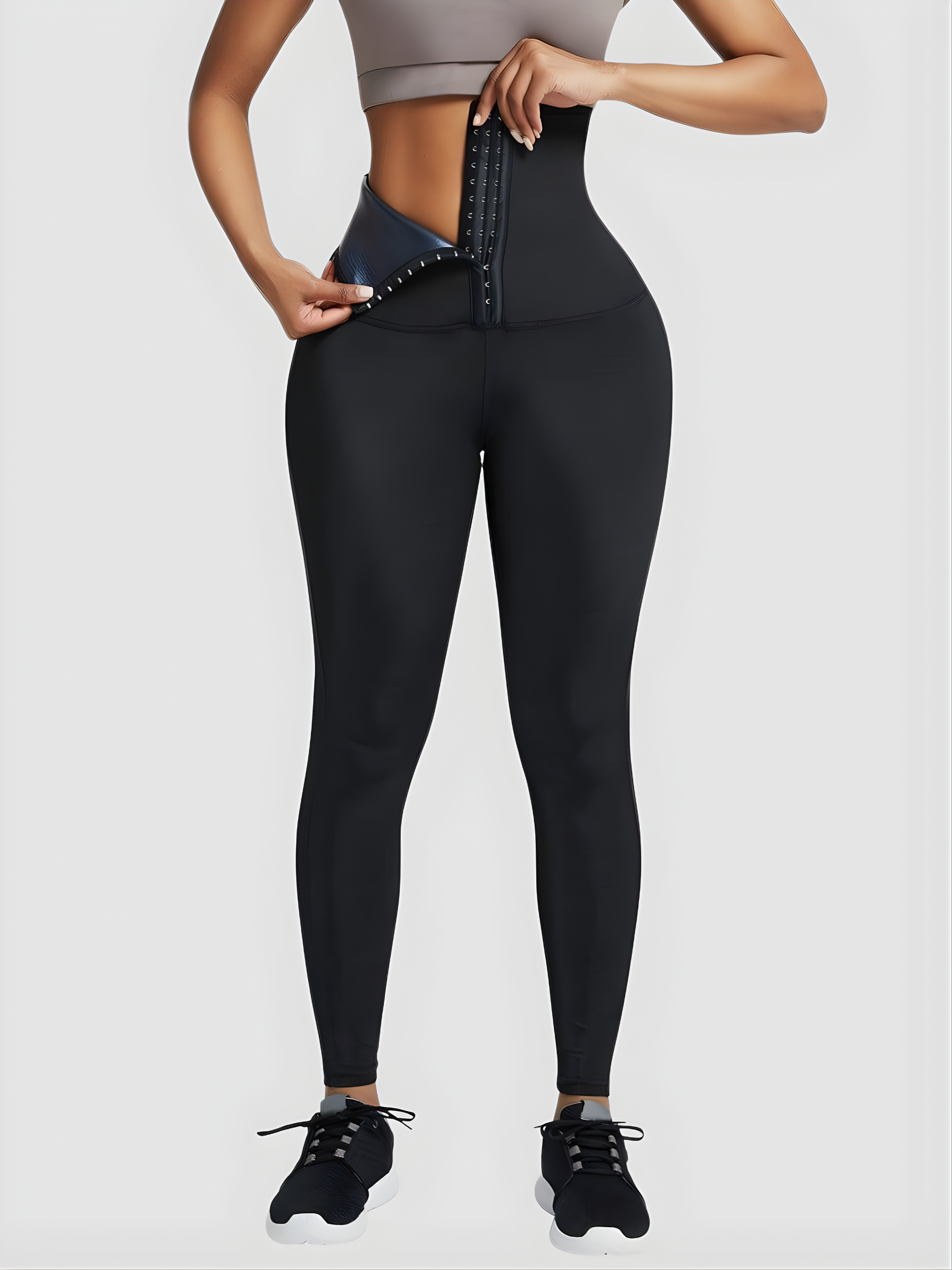 Woman opening the corset closure on BodyFlexx Shapewear's black Sauna Sweat Belt Leggings.