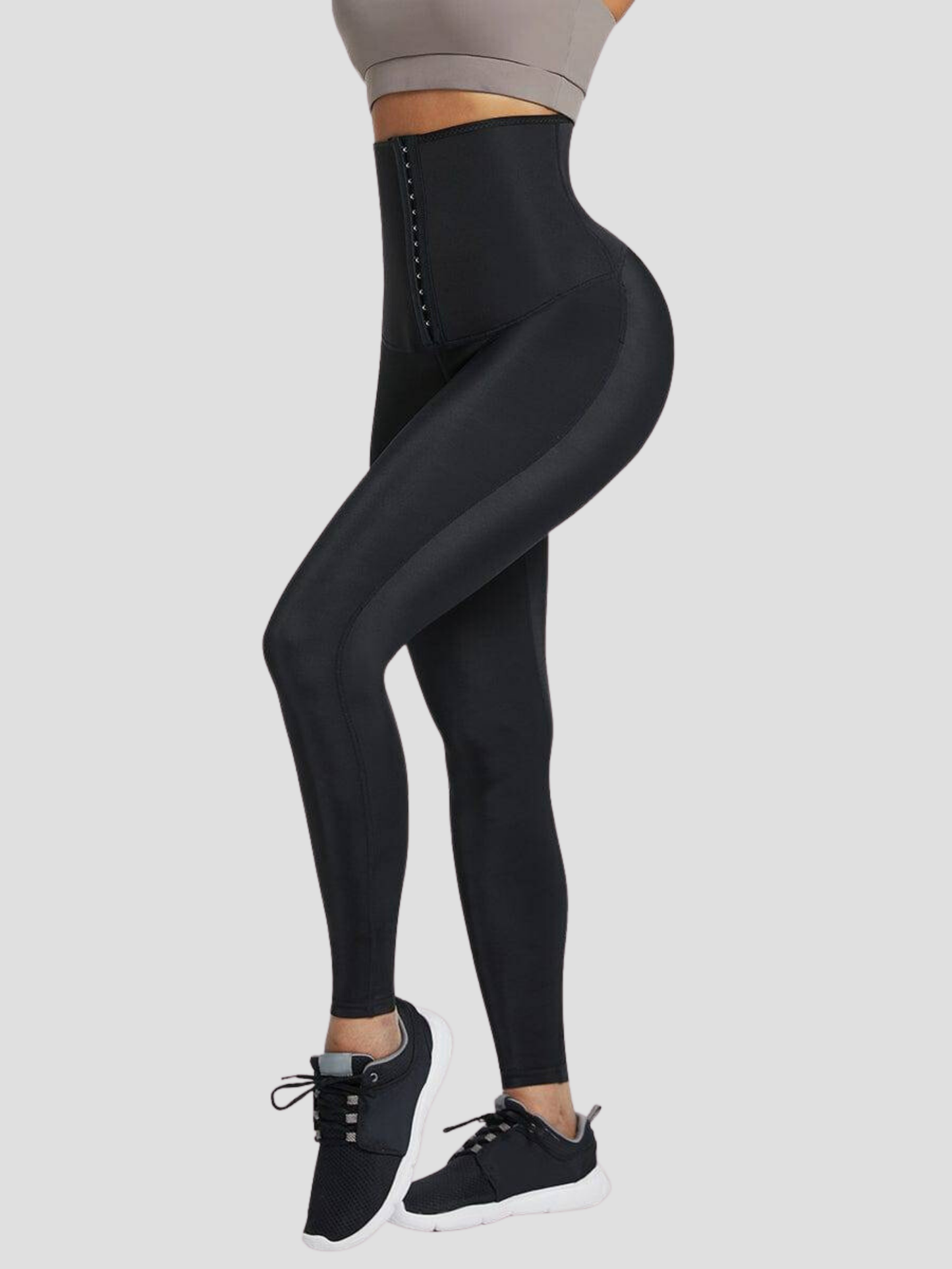 Woman wearing black high-waisted sauna leggings by BodyFlexx.