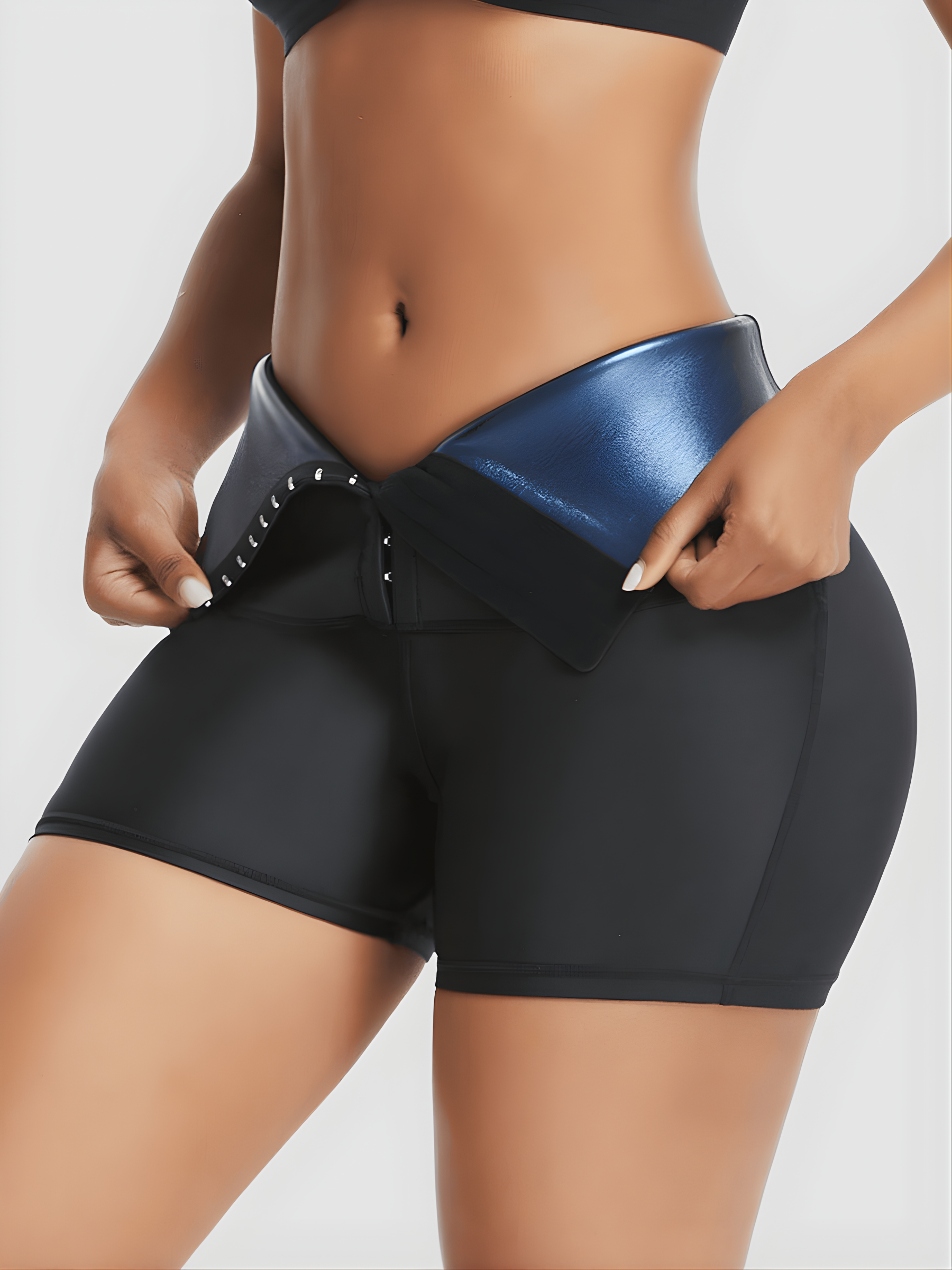 Woman wearing black BodyFlexx Waist-Training Sauna Shorts. She's opening the corset closure to show the blue neoprene lining.