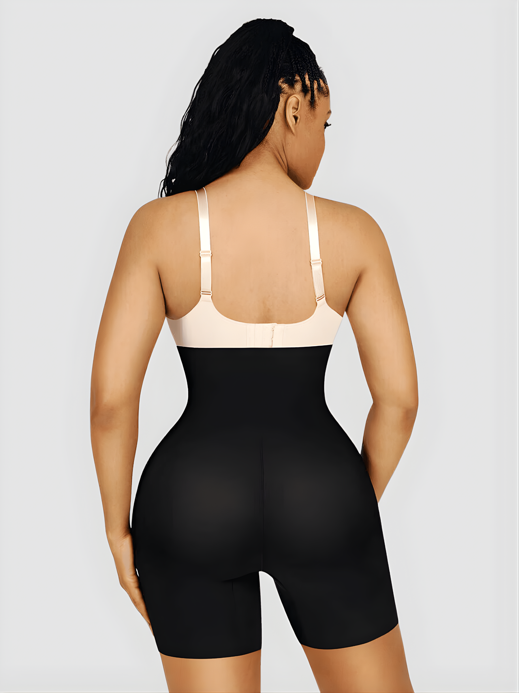 Woman wearing a black tummy control shapewear garment with removable bum padding for a curvy BBL-effect.