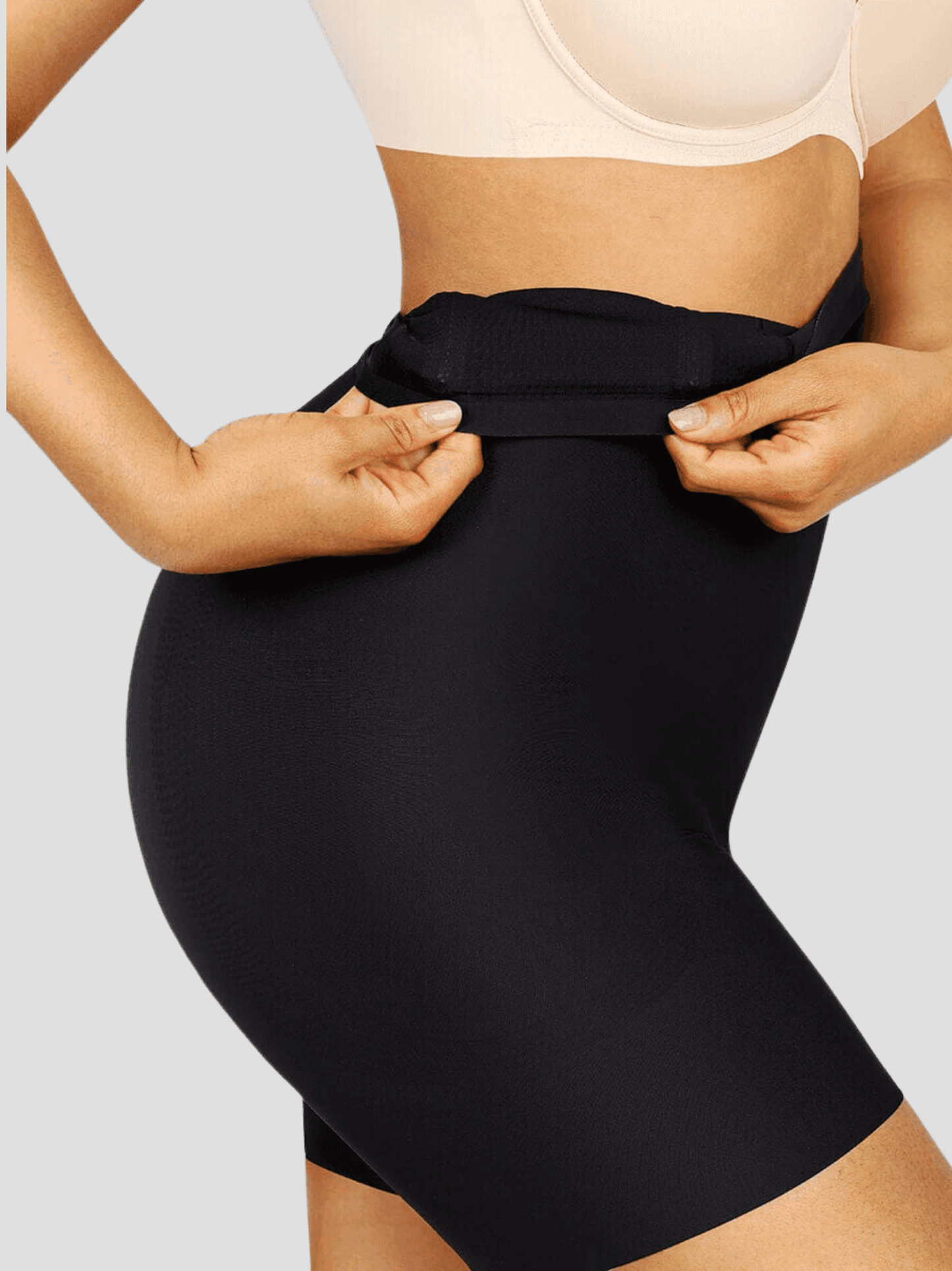 Woman wearing a black high-waisted shaping bottoms with removable bum pads by BodyFlexx Shapewear.