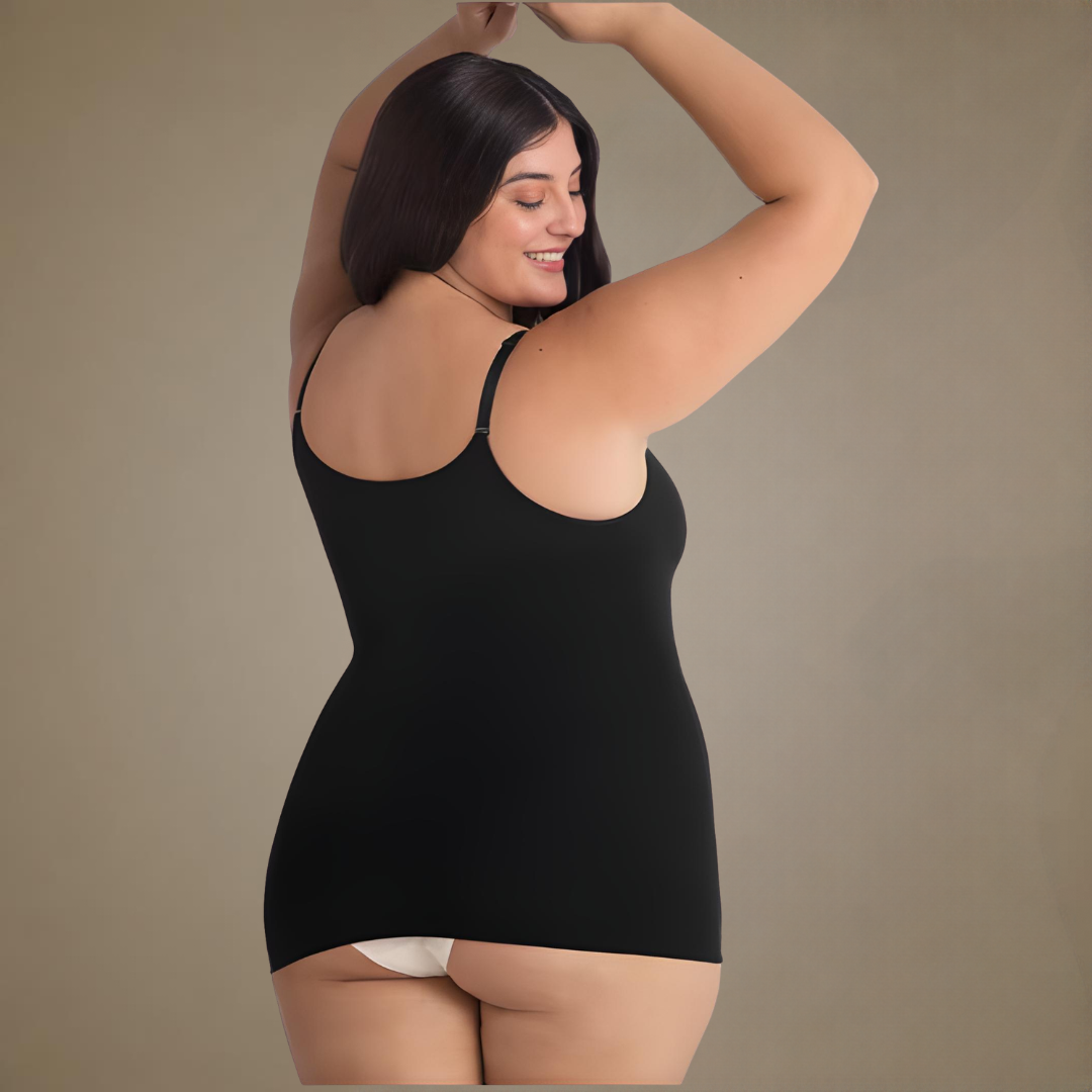 A woman modeling a black sleeveless  shaping camisole with built-in shapewear from the back, shown against a plain warm beige studio background.