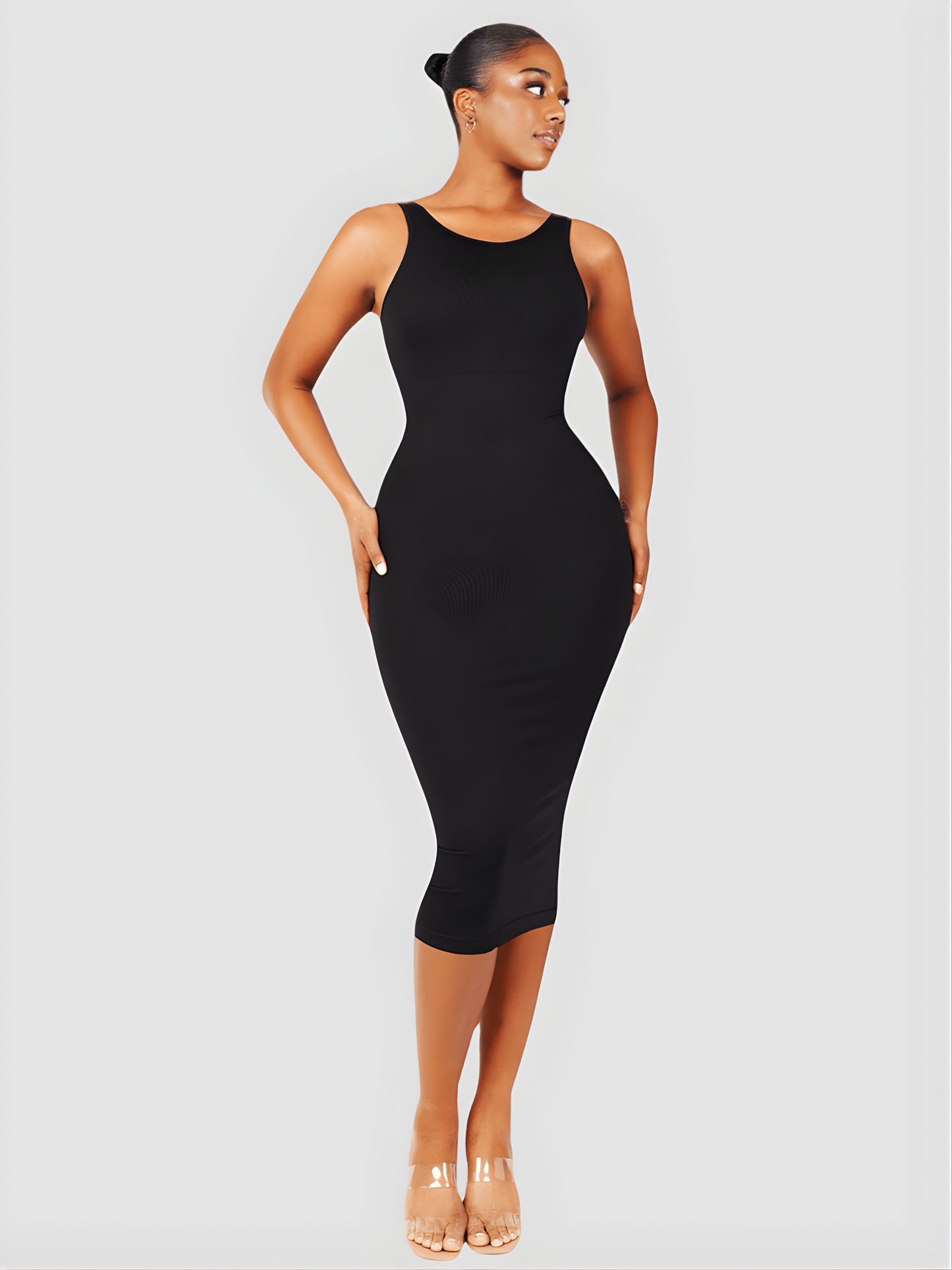 Woman wearing a black sleeveless midi shapewear dress by BodyFlexx.