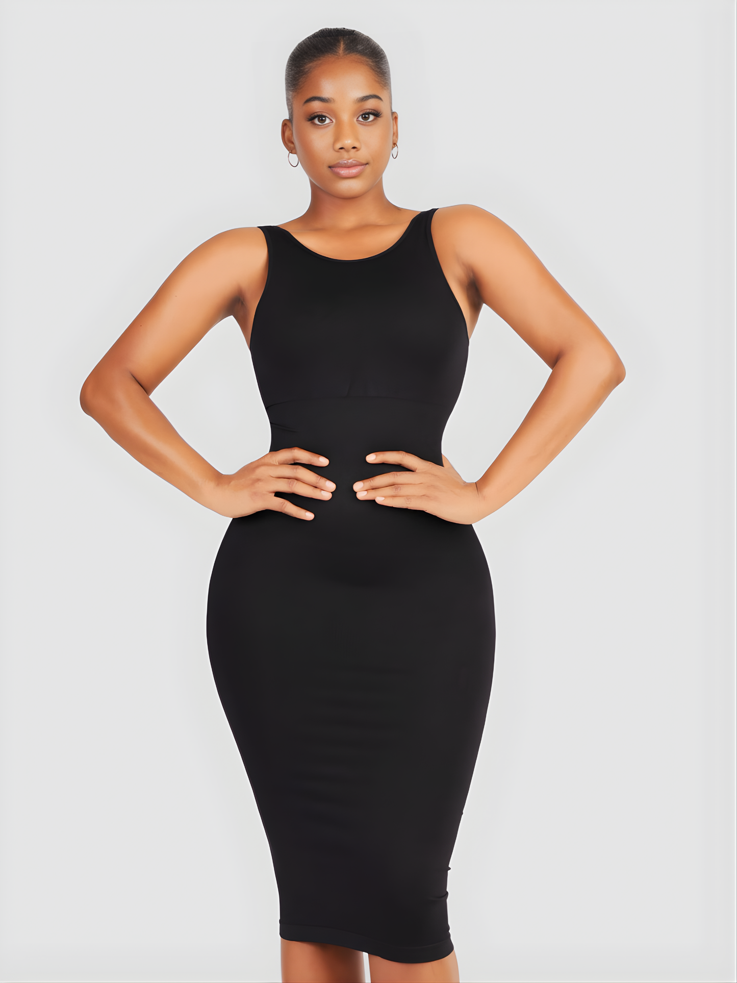 Woman wearing a black sleeveless midi shaping dress with built-in shapewear by BodyFlexx.