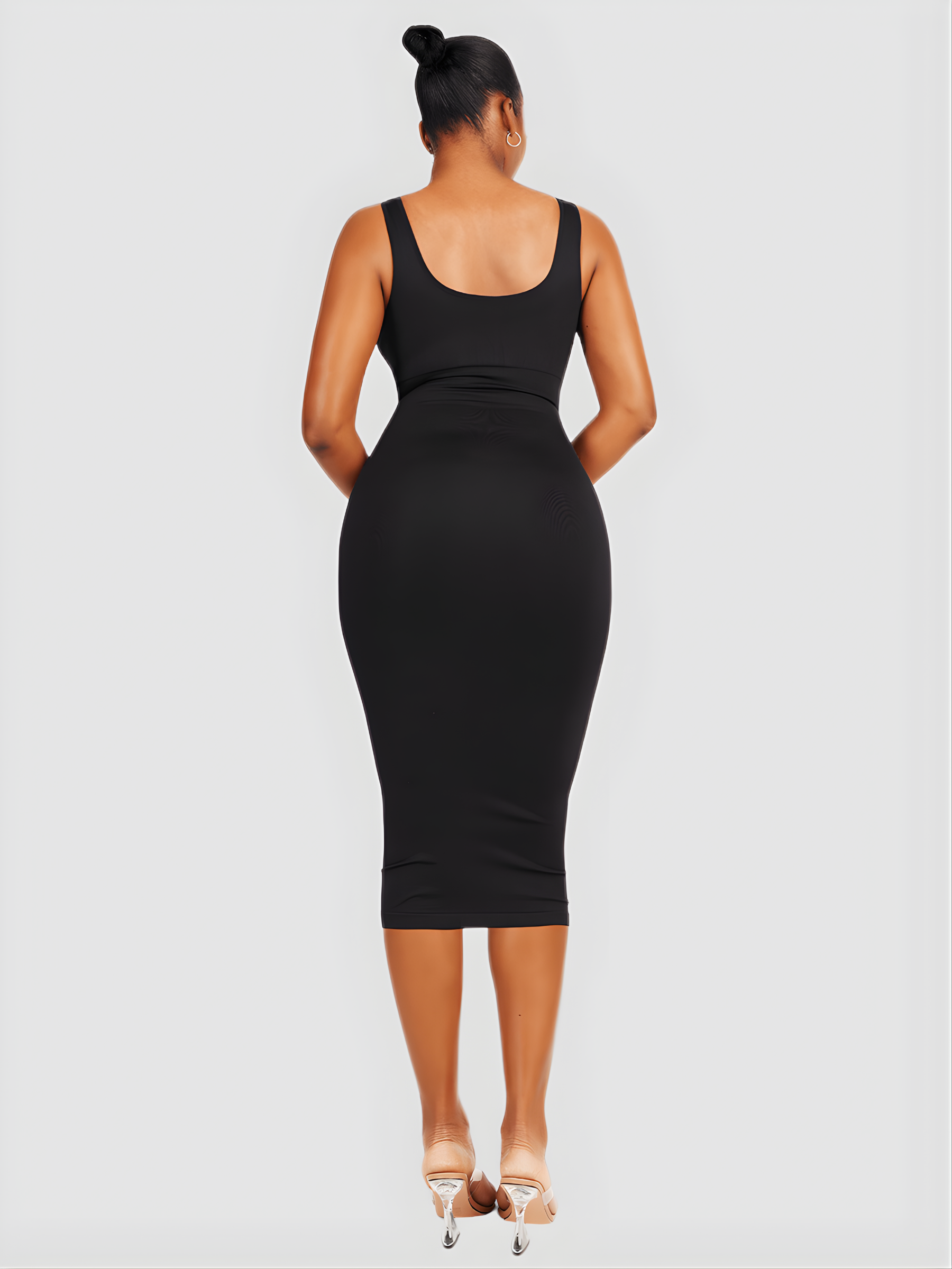 Woman wearing a black sleeveless shaping dress with built-in shapewear by BodyFlexx.
