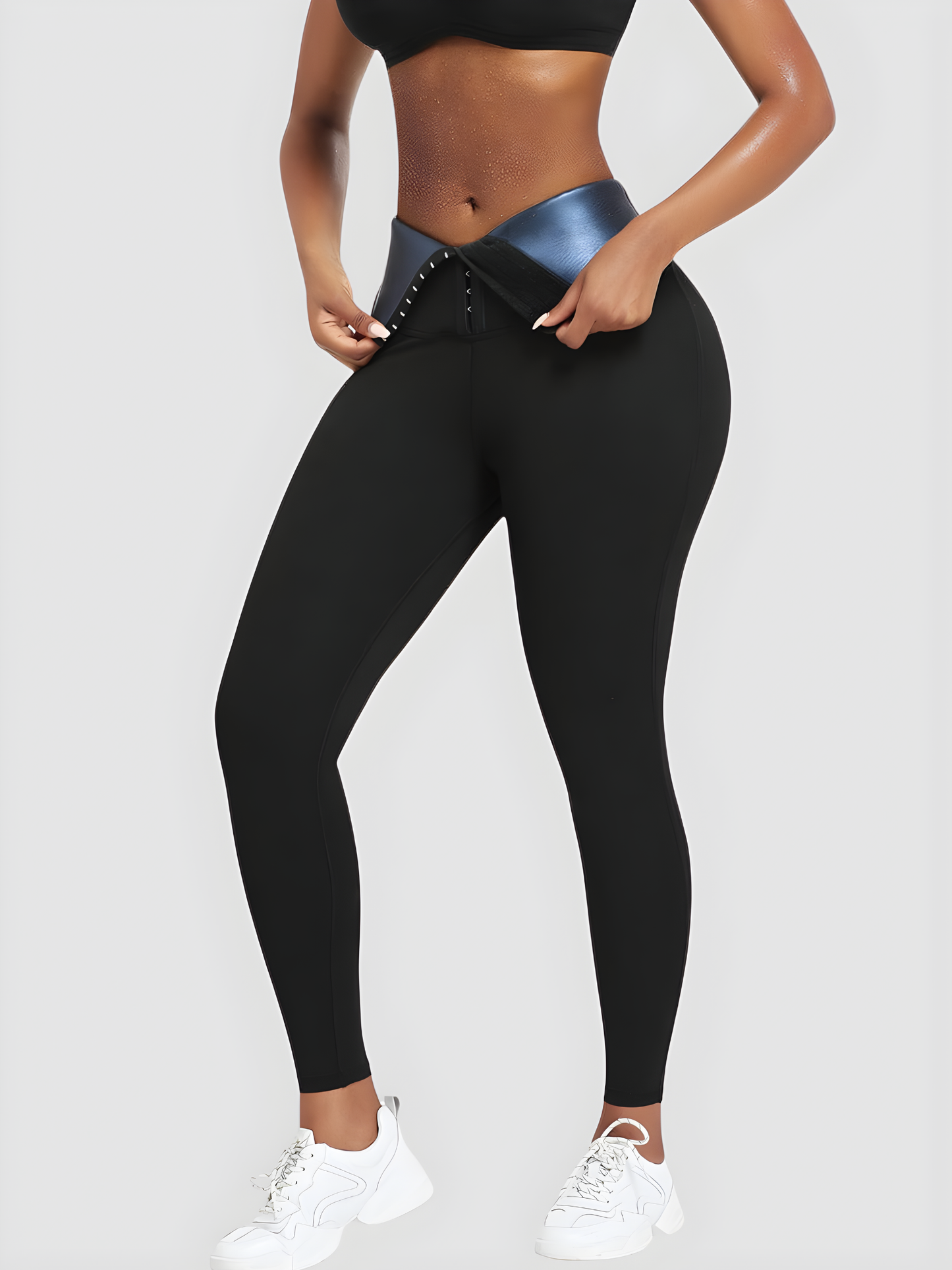 Woman wearing black BodyFlexx Waist-Training Sauna Leggings with the corset closure open showing a sweaty stomach after working out.