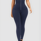 Woman wearing blue waist training leggings with an extra high corset-style closure to flatten her tummy and sculpt her curves.
