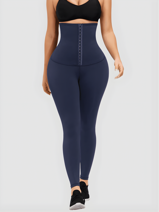 Woman wearing blue waist training leggings with an extra high corset-style closure to flatten her tummy and sculpt her curves.