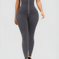 Woman wearing gray waist training leggings with an extra high corset-style closure to flatten her tummy and sculpt her curves.