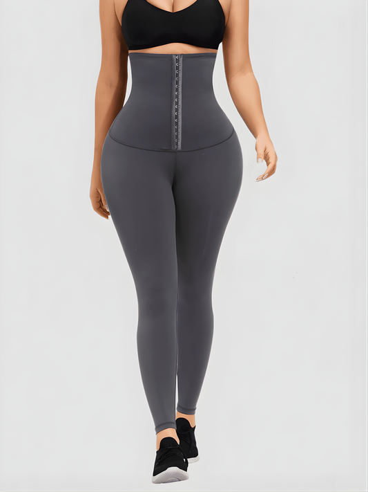 Woman wearing gray waist training leggings with an extra high corset-style closure to flatten her tummy and sculpt her curves.