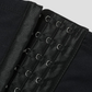 Close-up of a the corset-style hook and eye closure on a pair of black waist trainer leggings by BodyFlexx.
