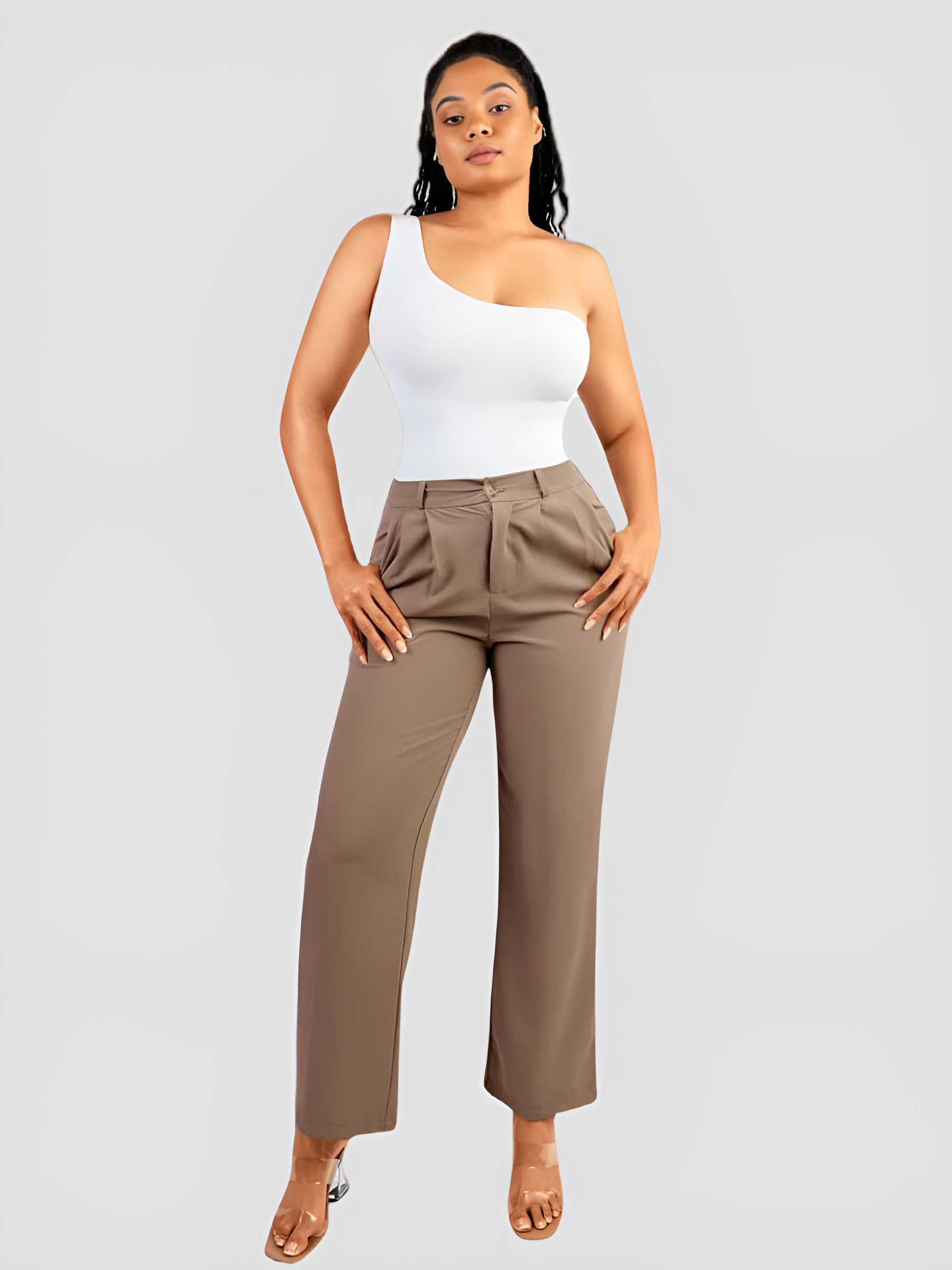 A woman wearing a white off-the-shoulder shaping bodysuit with built-in tummy-control shapewear paired with tan pants flaunting her curves.