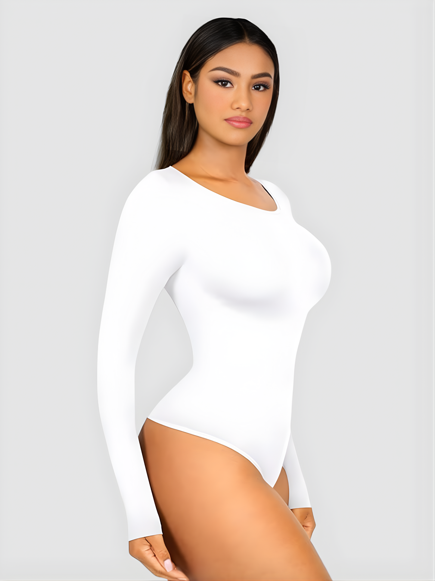 Woman wearing a white long-sleeve sculpting bodysuit by BodyFlexx Shapewear.