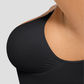 Woman wearing a black shapewear camisole with tummy control and adjustable straps, highlighting the bust support.