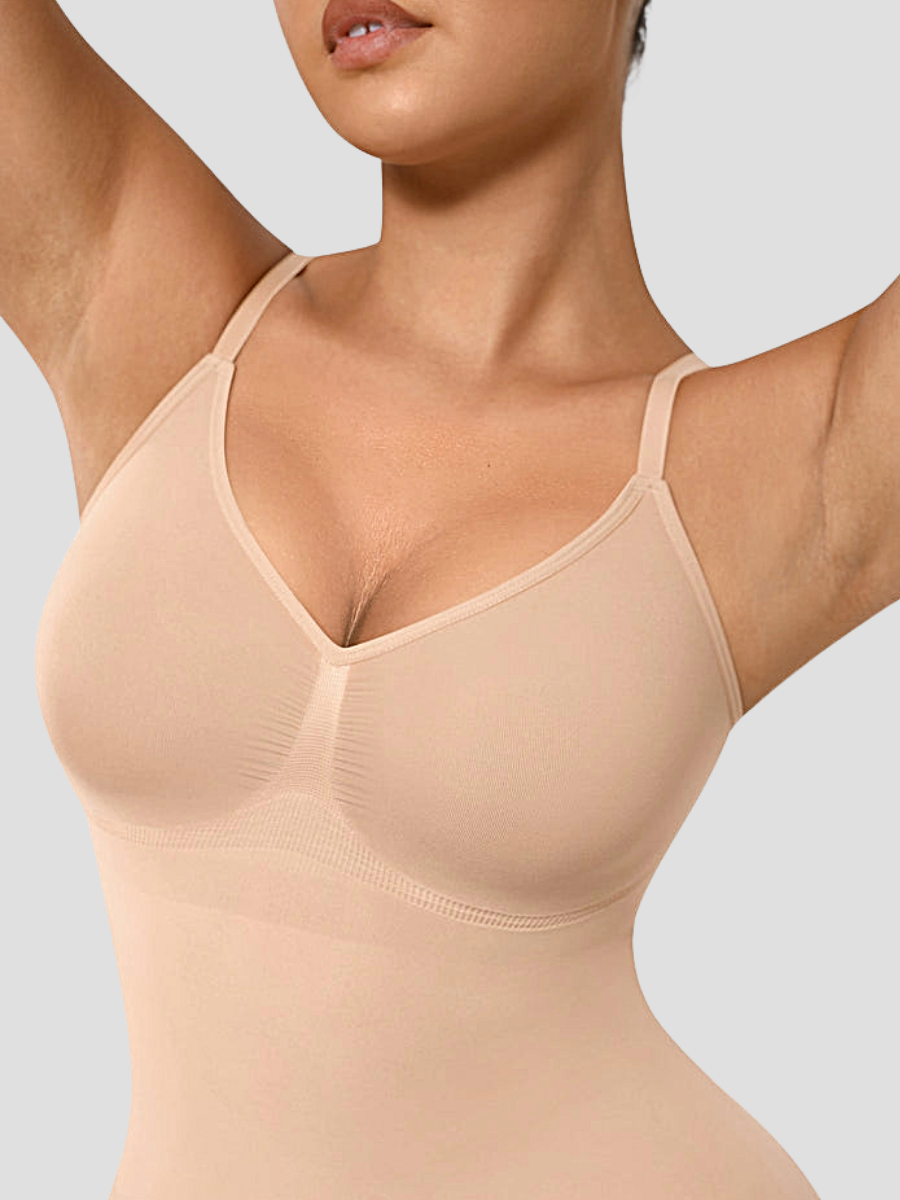 Woman wearing a nude colour mid-thigh tummy-control seamless shapewear bodysuit by BodyFlexx 