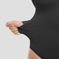 Woman wearing a black long-sleeve tummy-control shapewear bodysuit top by BodyFlexx.