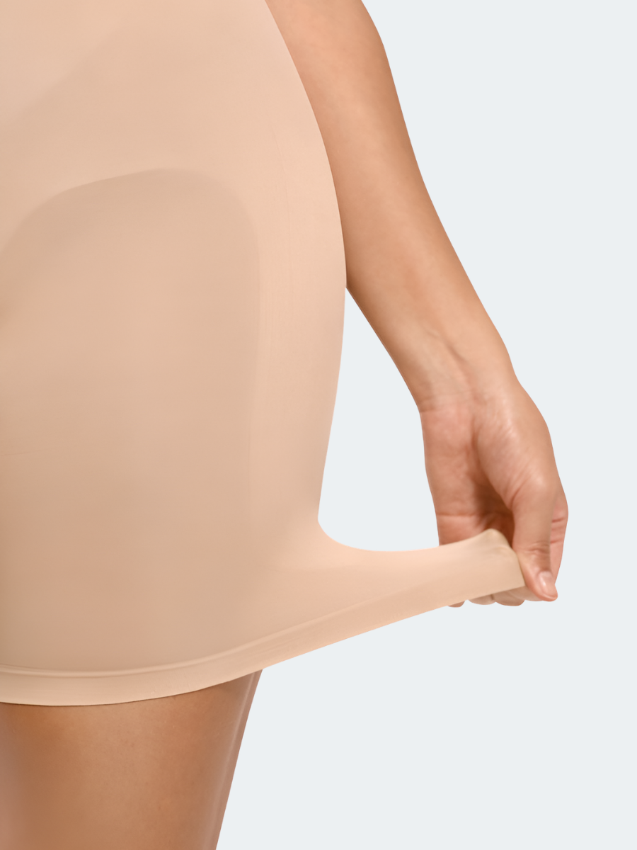 Woman wearing a nude color mid-thigh seamless shapewear bodysuit by BodyFlexx 