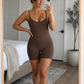 Woman wearing a brown mid-thigh shapewear bodysuit taking a mirror selfie by BodyFlexx .